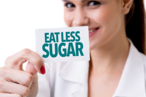 Woman holding a sign that says eat less sugar