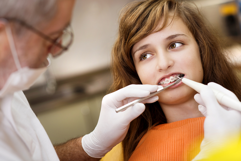 Girl with braces having a dental exam