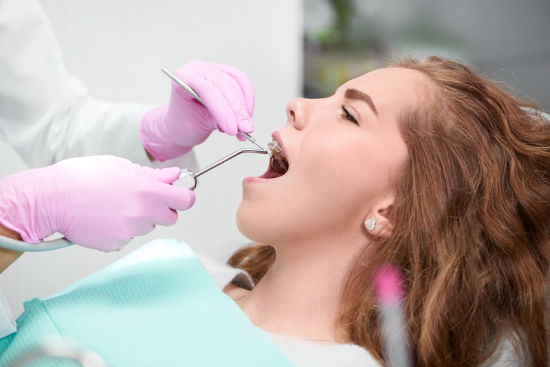 A young girl having her mouth looked at by a dentist.